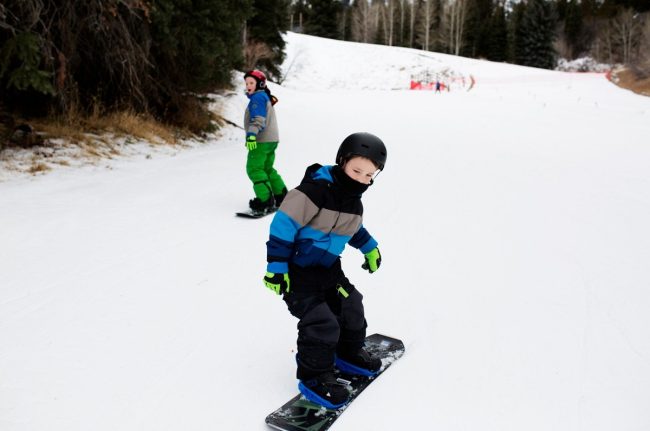 dzieci na snowboardzie na stoku