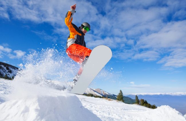 człowiek jadący na snowboardzie na stoku